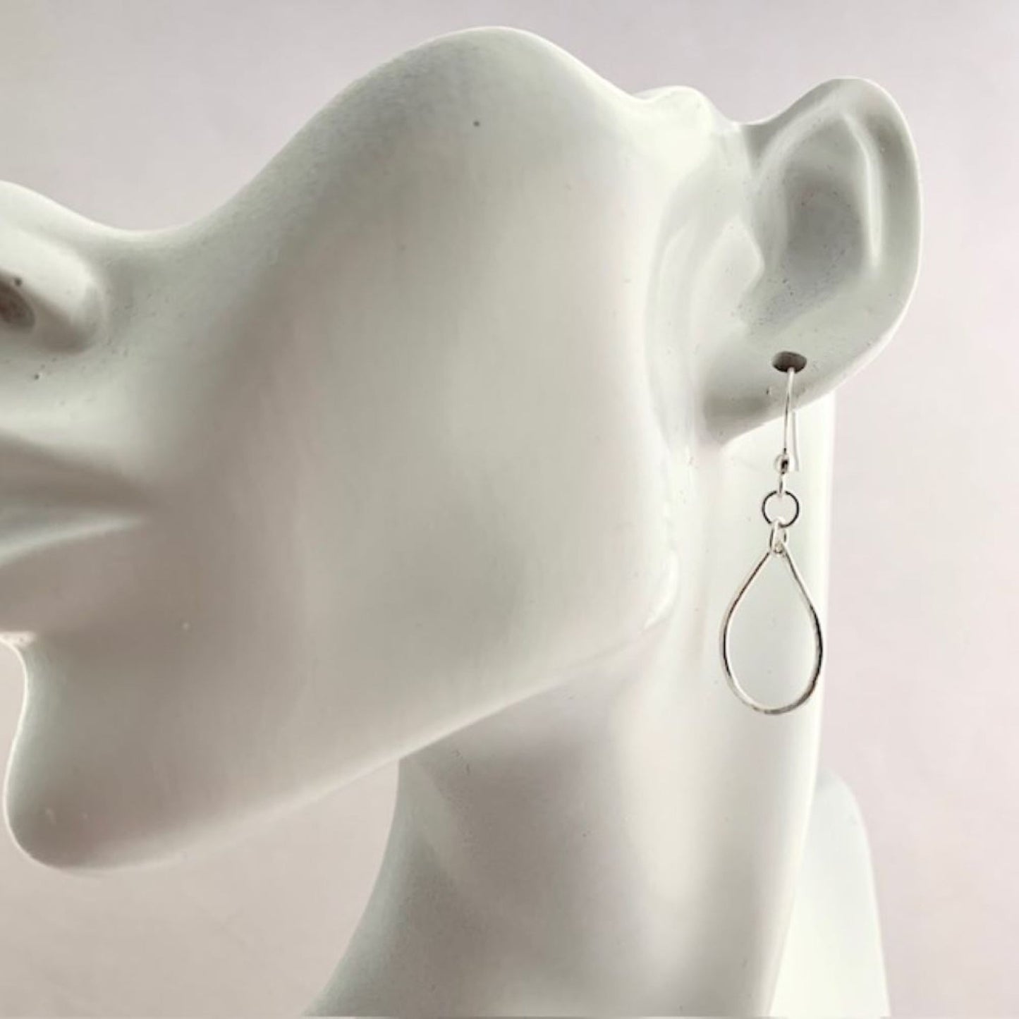 Sterling Silver teardrop shaped earrings on a white mannequin ear