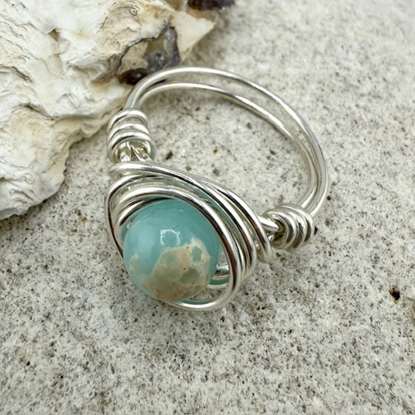 Silver ring with a aqua gemstone on a stone surface