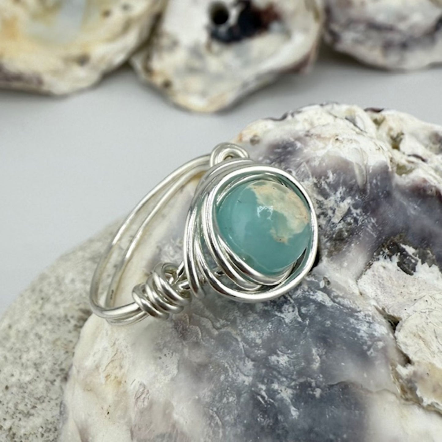 Silver ring with an aqua stone on a oyster shell