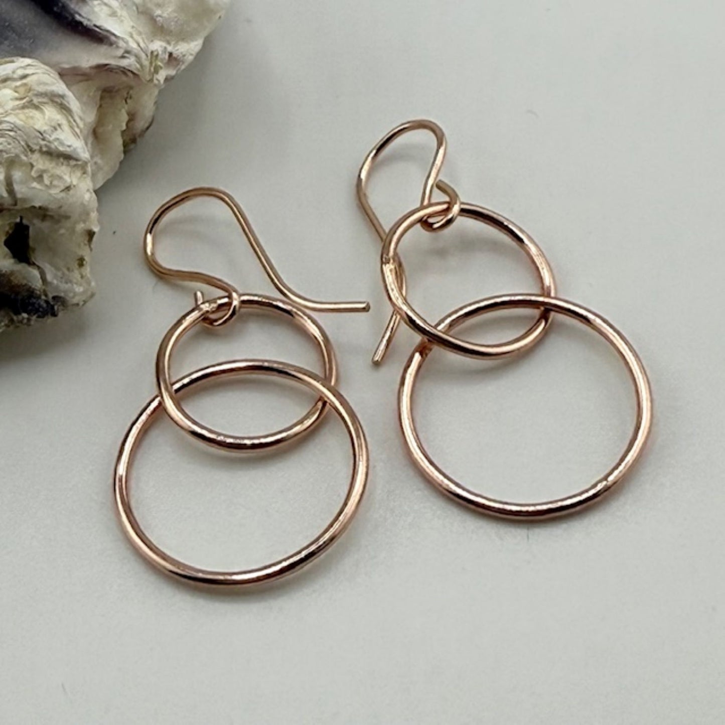 Rose gold hoop earrings on a light background