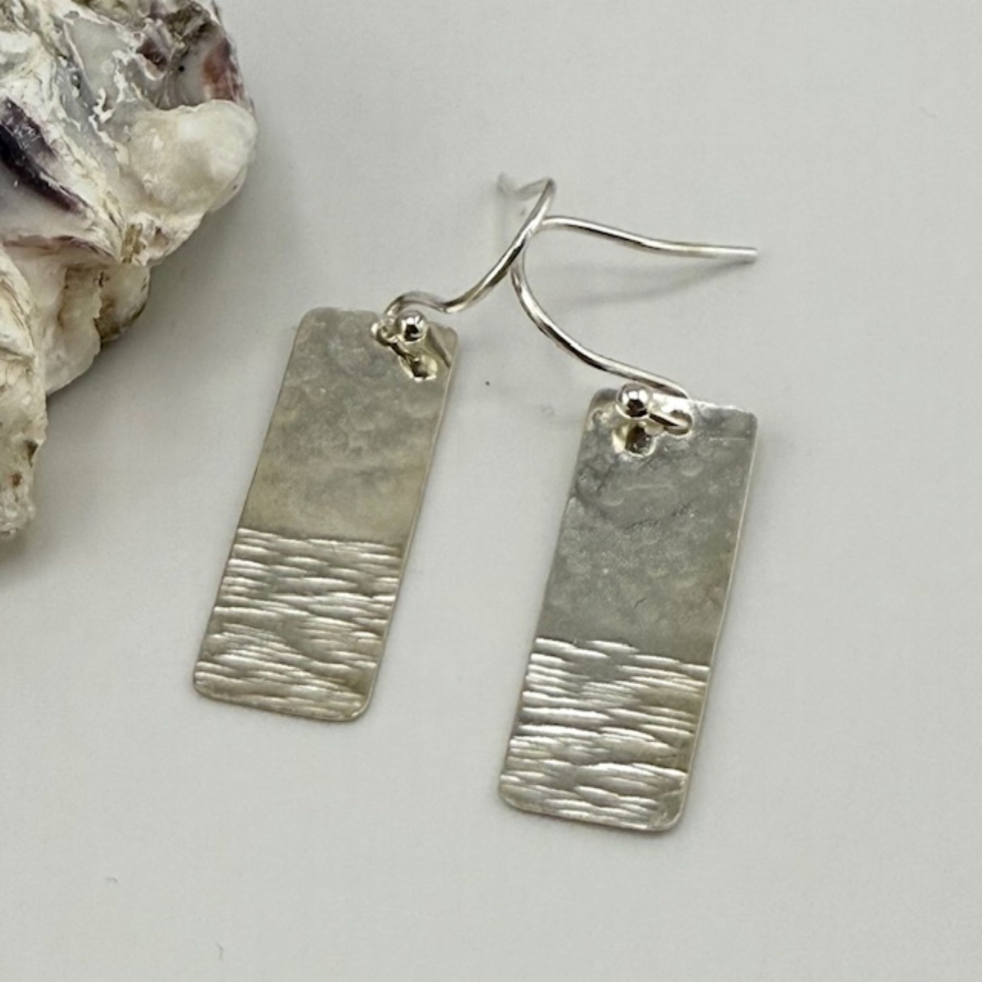 Pair of silver bar earrings on a light gray background