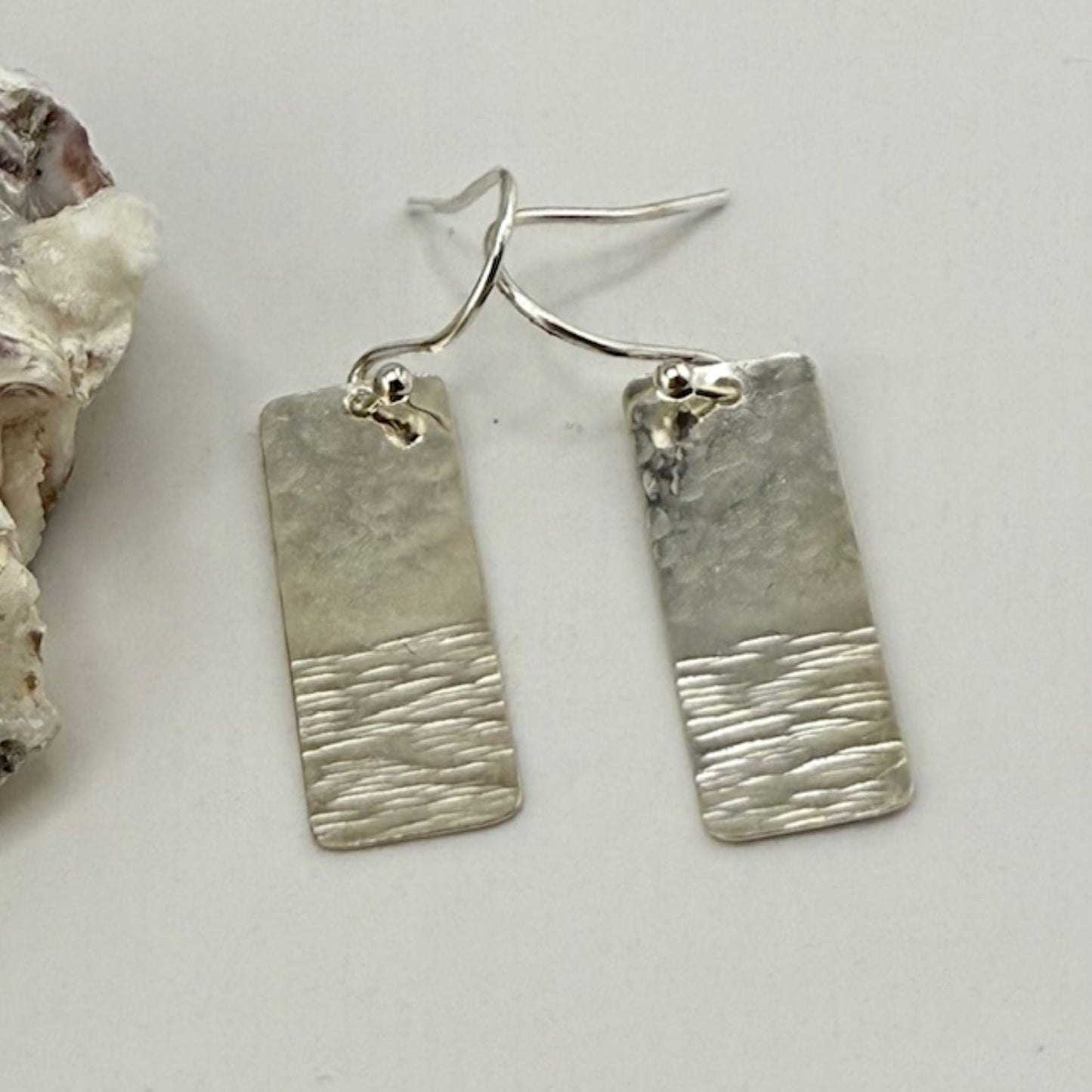 925 sterling silver textured bar earrings on a plain surface