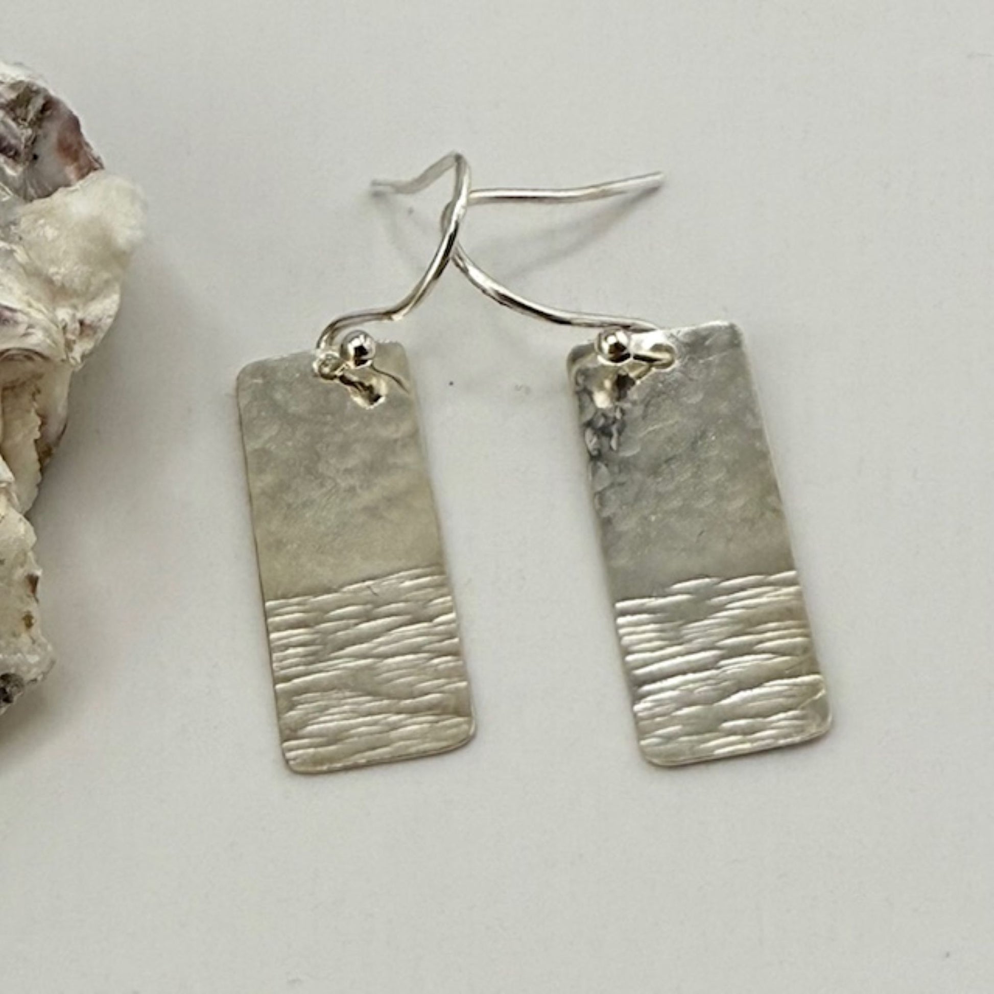 925 sterling silver textured bar earrings on a plain surface