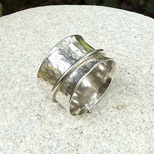 Silver spinning ring on a textured stone surface
