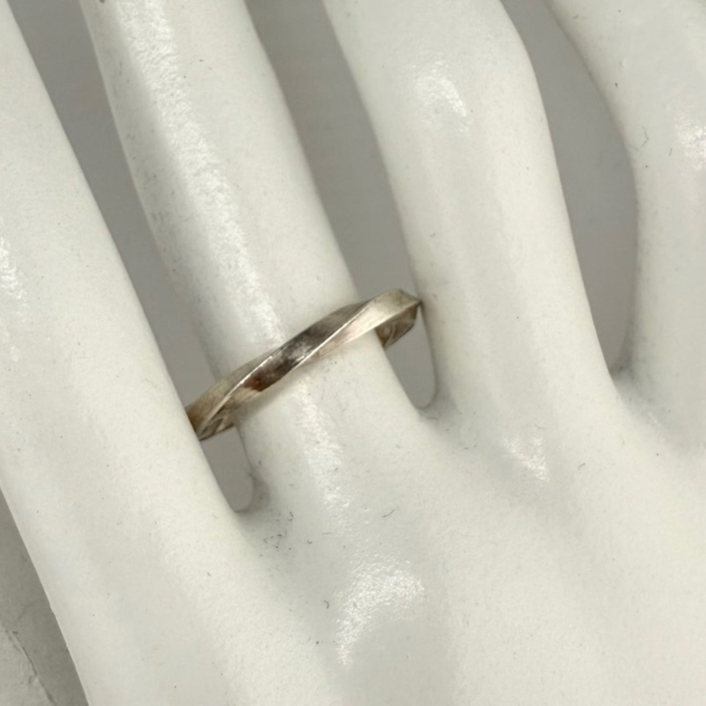 Silver ring on a white marble hand model
