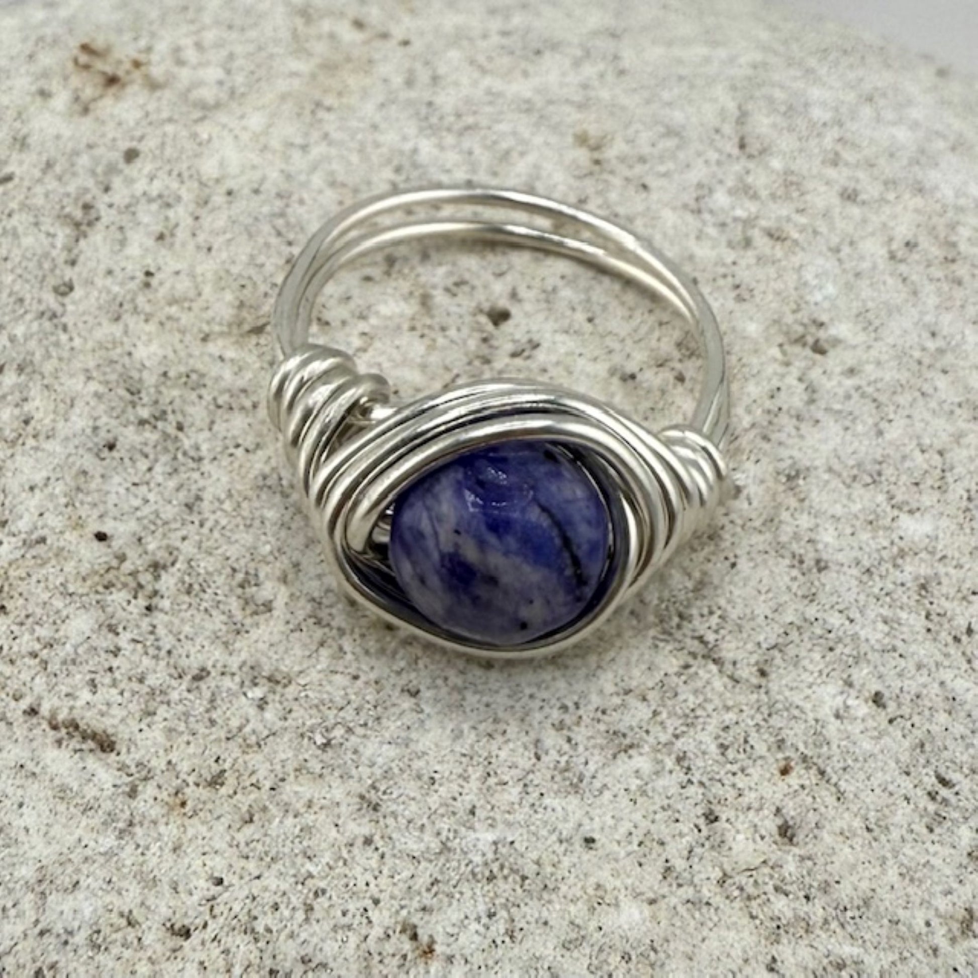 Round lapis lazuli gemstone ring on a stone background