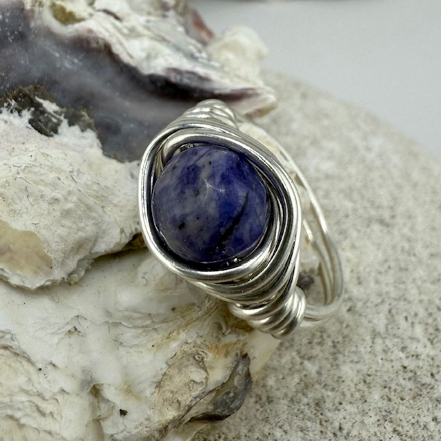 Lapis lazuli gemstone ring sitting on an oyster shell