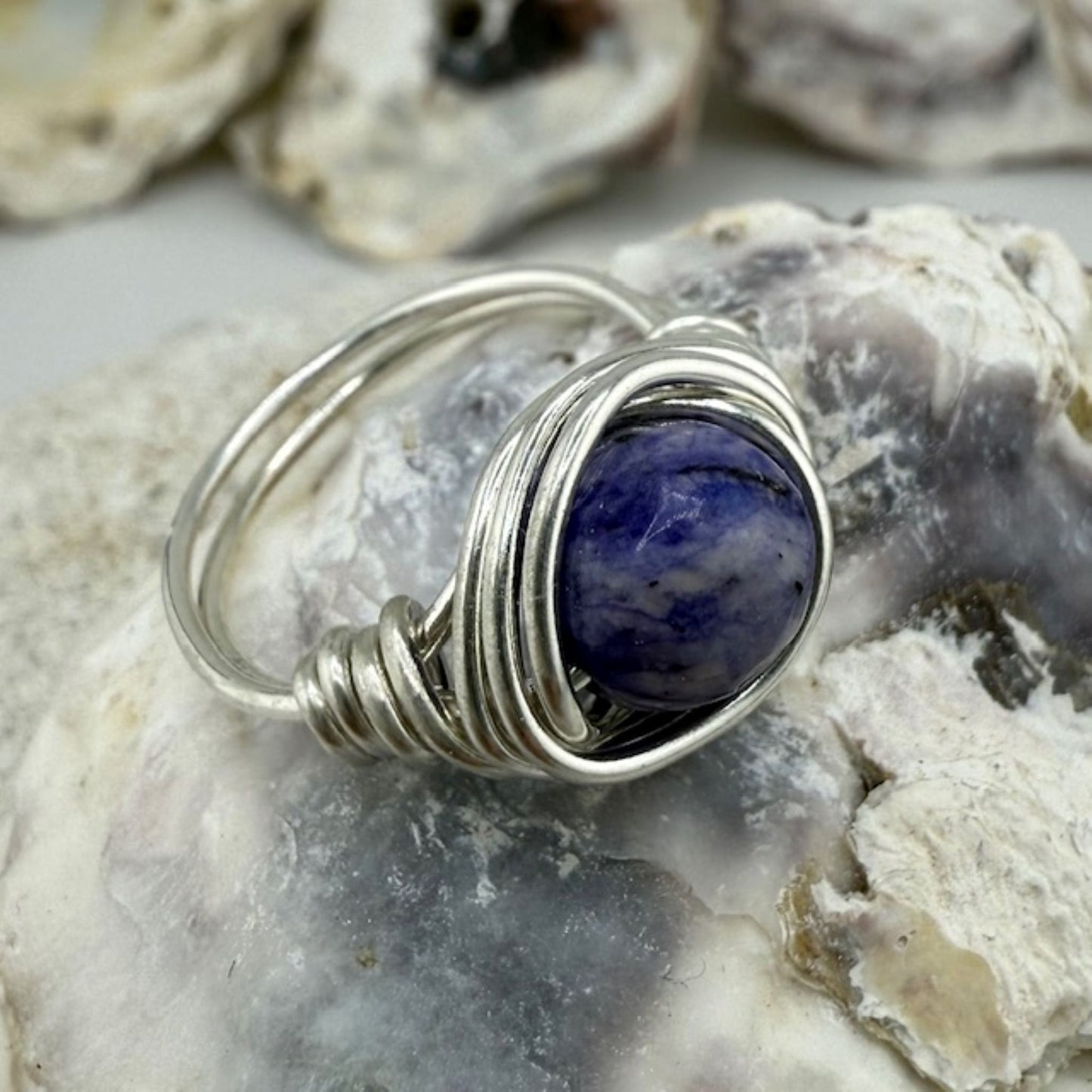 Silver ring with a blue lapis lazuli stone on a textured surface