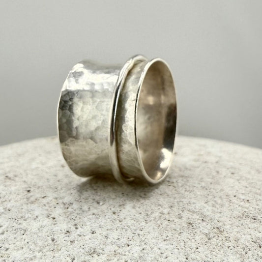 Sterling Silver spinner ring with textured surface on a natural stone