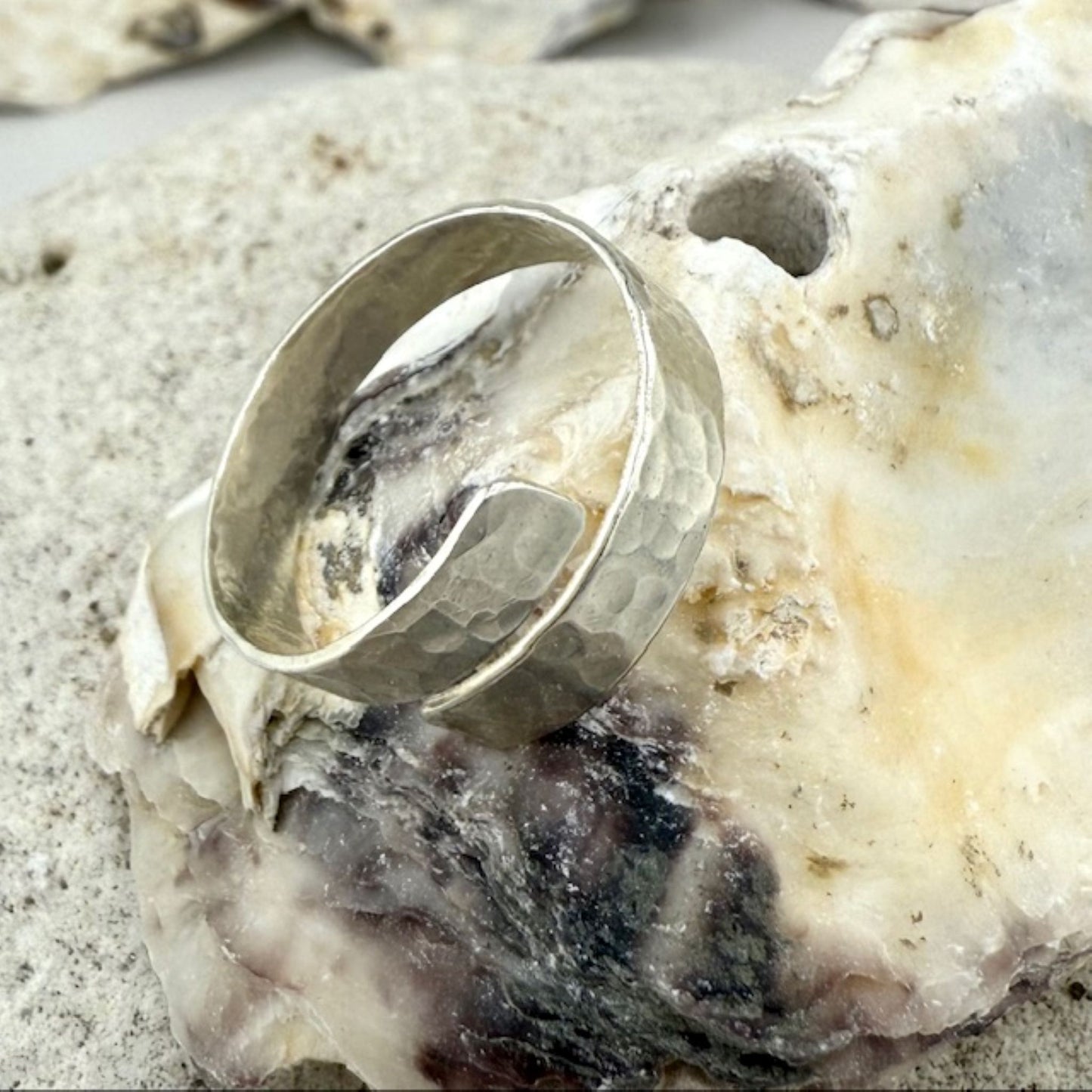 Silver ring on a textured oyster shell surface