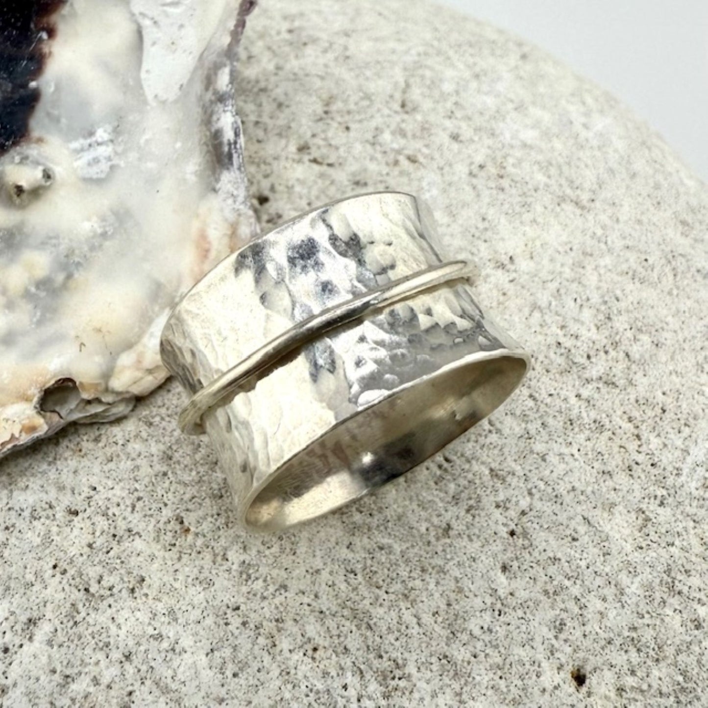 Silver spinner ring on a natural stone background