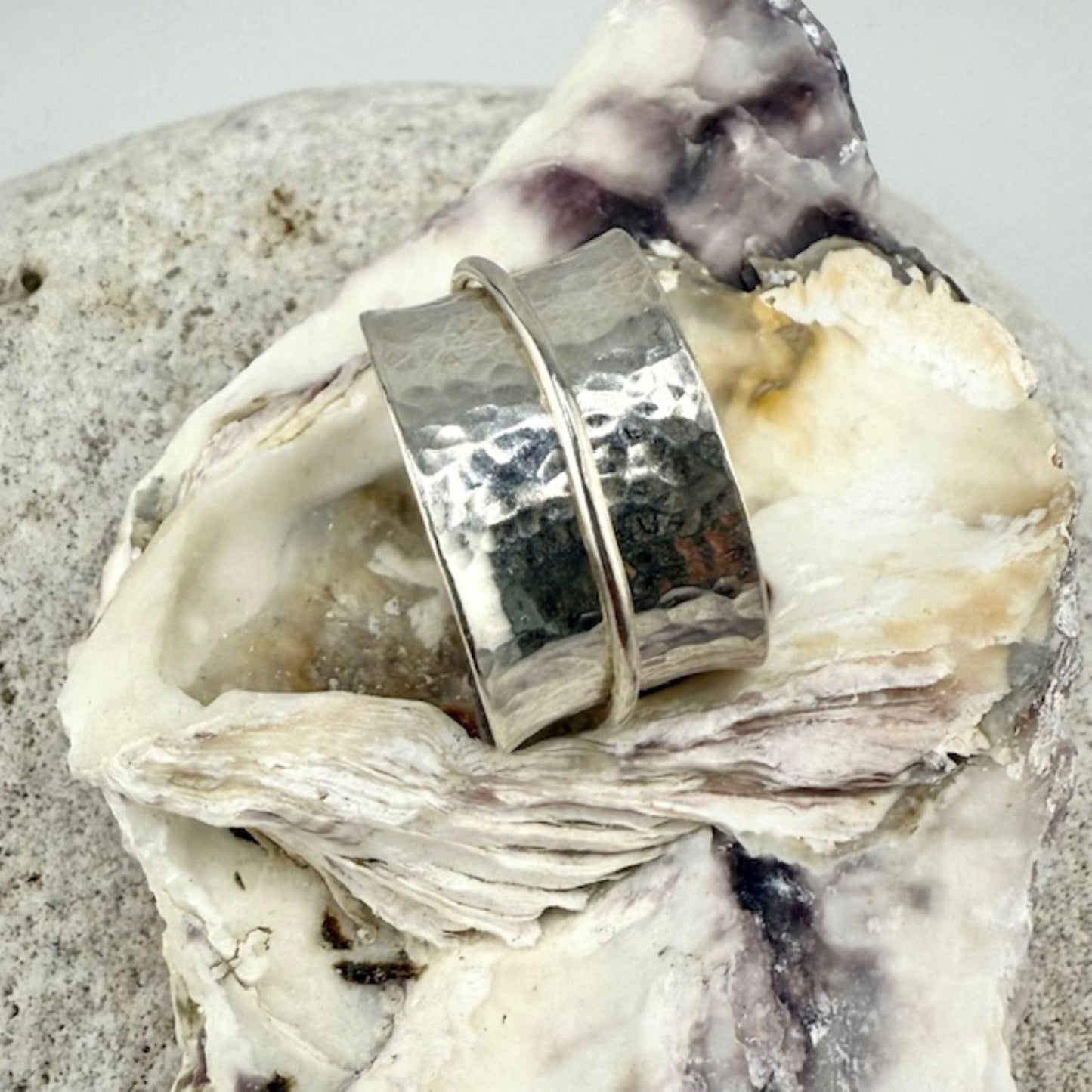Silver spinner ring on a textured stone surface