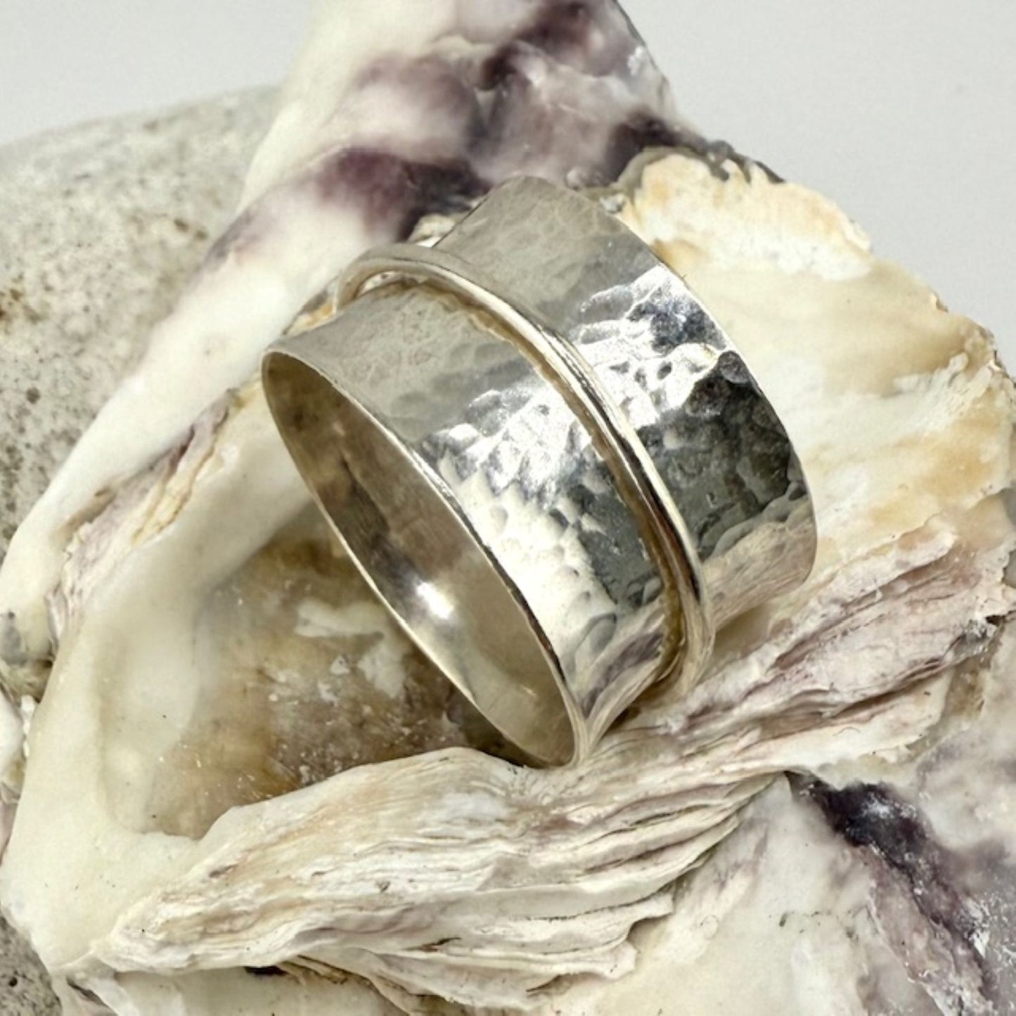 Silver spinner ring on a textured surface