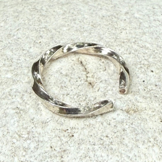 Silver ring on a white stone surface