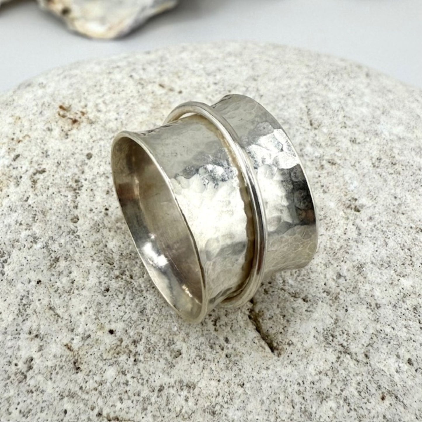Silver spinner ring on a textured surface