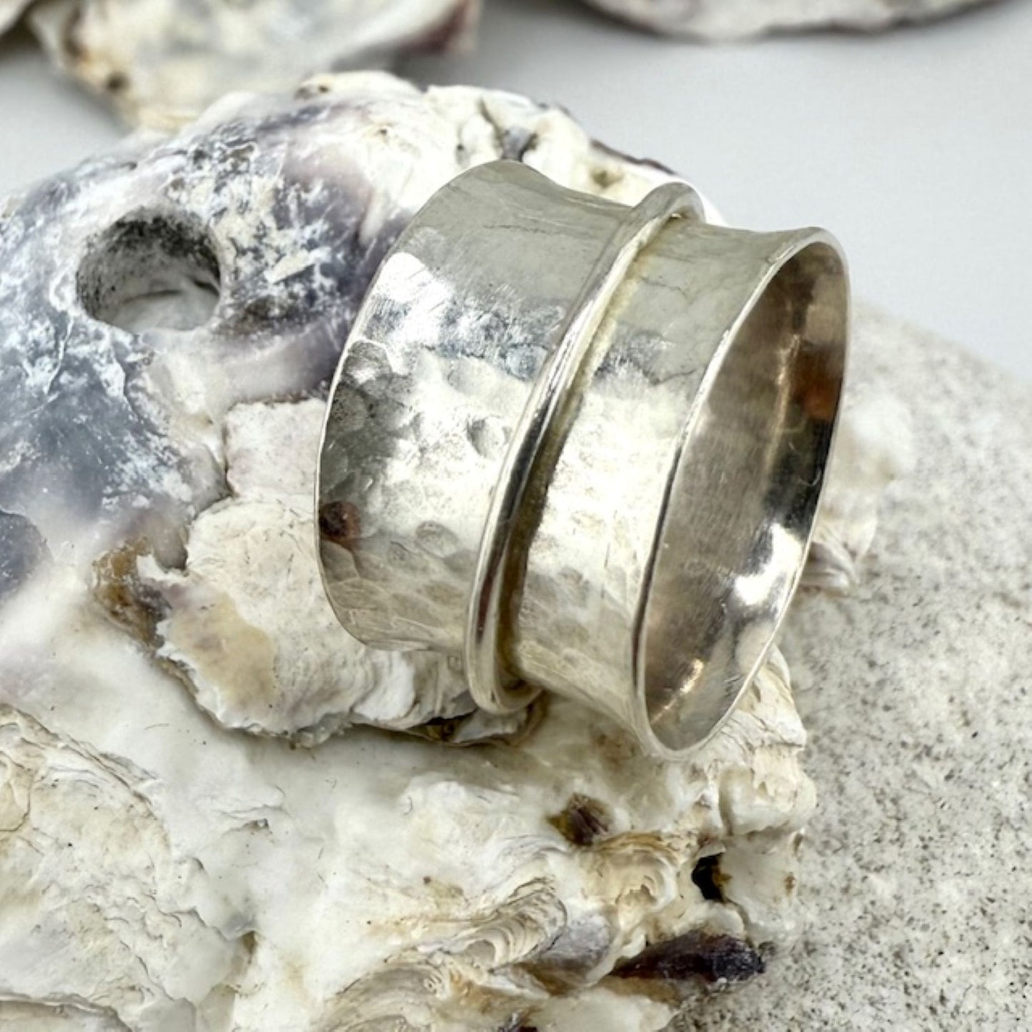 Silver spinner ring on a textured surface
